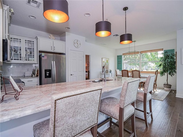 2284 Timberlake Cir, Vero Beach, FL 32966 - kitchen featuring appliances with stainless steel finishes, glass insert cabinets, dark wood finished floors, light stone countertops, and tasteful backsplash