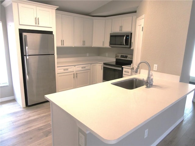 1465 24th Ave SW, Vero Beach, FL 32962 - kitchen featuring appliances with stainless steel finishes, a peninsula, a sink, light wood finished floors, and light countertops