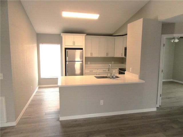 1465 24th Ave SW, Vero Beach, FL 32962 - kitchen with freestanding refrigerator, a sink, vaulted ceiling, dark wood-style flooring, and light countertops