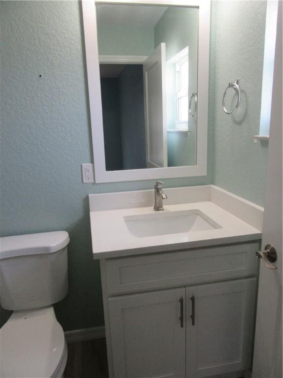 1465 24th Ave SW, Vero Beach, FL 32962 - half bathroom featuring vanity, toilet, and a textured wall