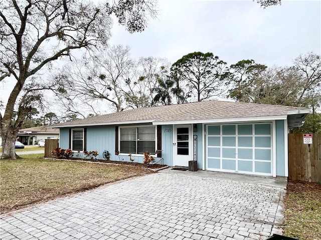 ranch-style home with a garage and a front lawn