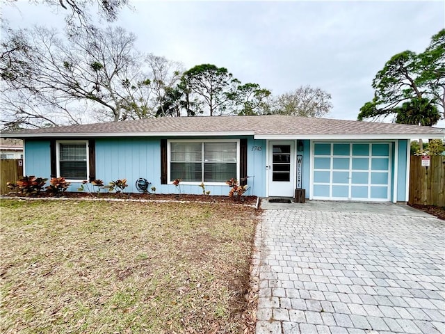 ranch-style home with a garage and a front yard