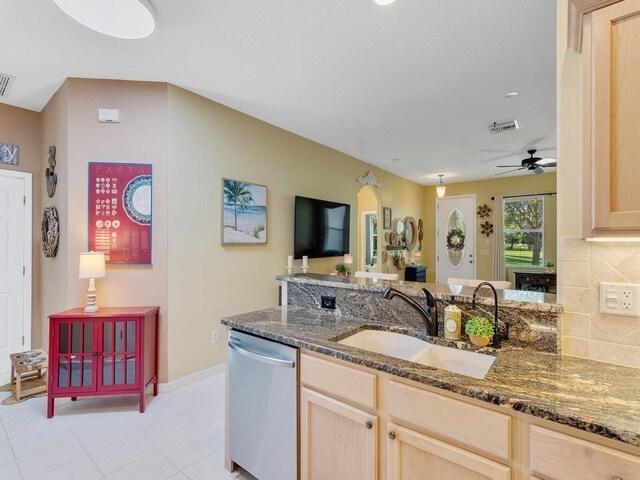 7639 15th Ln, Vero Beach, FL 32966 - kitchen featuring dishwasher, light brown cabinets, a sink, decorative backsplash, and dark stone counters
