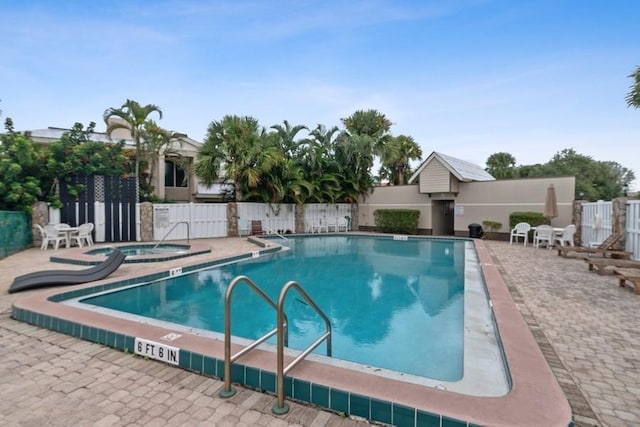community pool featuring a community hot tub and a patio