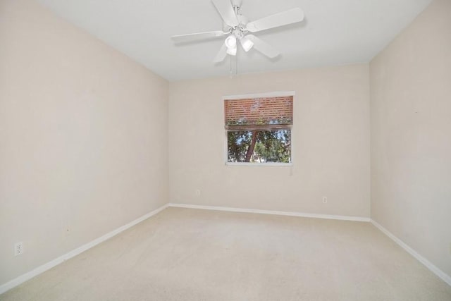 spare room featuring light colored carpet and ceiling fan