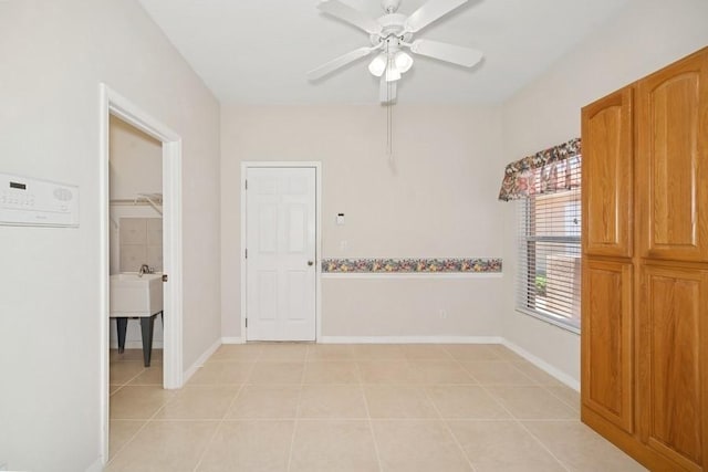 empty room with light tile patterned floors and a ceiling fan