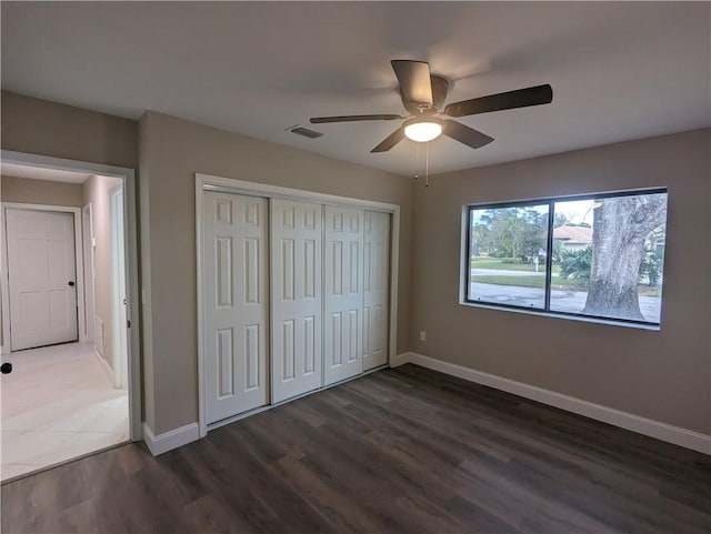 unfurnished bedroom with baseboards, visible vents, and wood finished floors