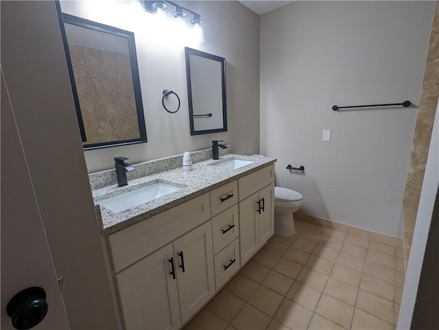 full bath featuring double vanity, a sink, toilet, and tile patterned floors
