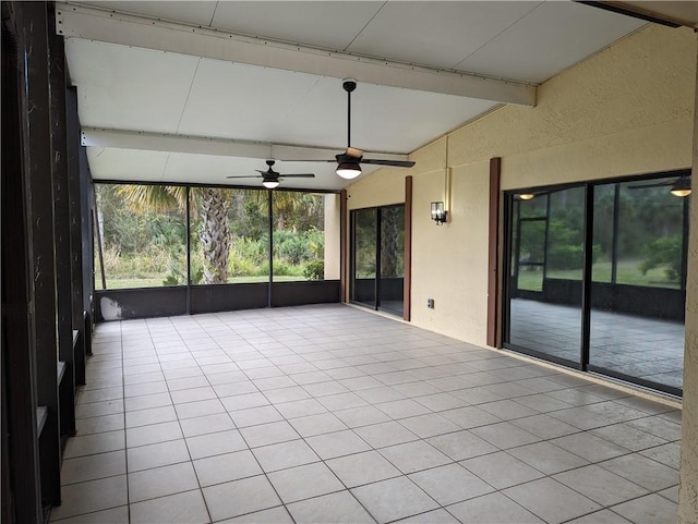 unfurnished sunroom featuring beamed ceiling and ceiling fan
