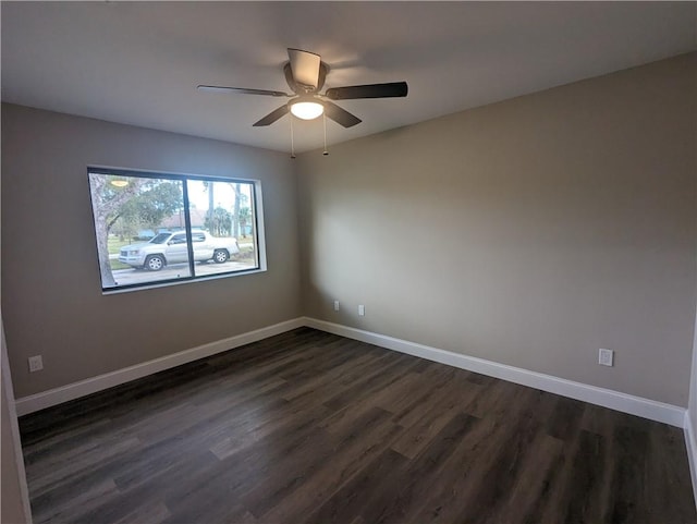 unfurnished room featuring baseboards, dark wood-type flooring, and a ceiling fan