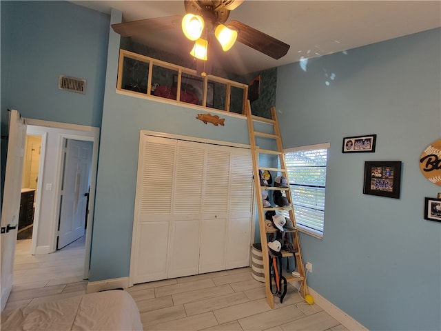 bedroom with light hardwood / wood-style flooring, ceiling fan, and a closet