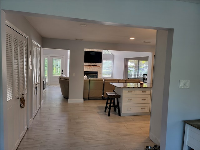 kitchen featuring white cabinets, a wealth of natural light, dark stone counters, and a breakfast bar area