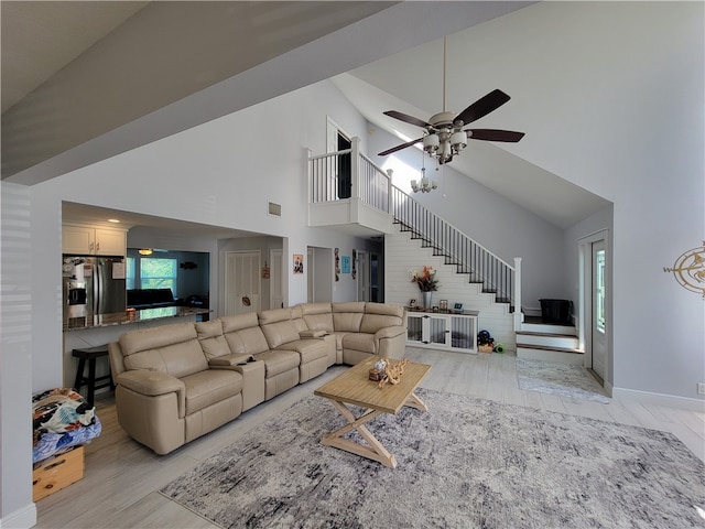 living room with ceiling fan, light wood-type flooring, and high vaulted ceiling