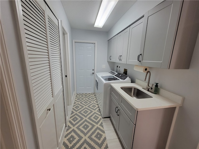 laundry room featuring cabinets, sink, and independent washer and dryer