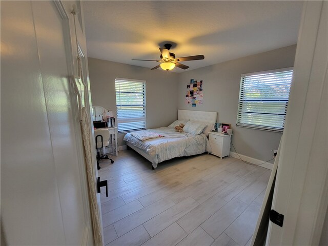 bedroom with light hardwood / wood-style floors and ceiling fan