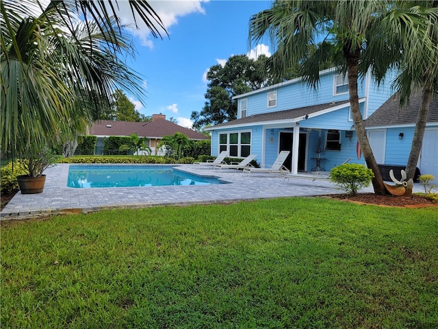 view of pool with a patio area and a lawn