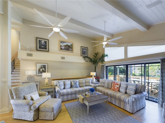 living room featuring ceiling fan, light hardwood / wood-style flooring, high vaulted ceiling, and beamed ceiling