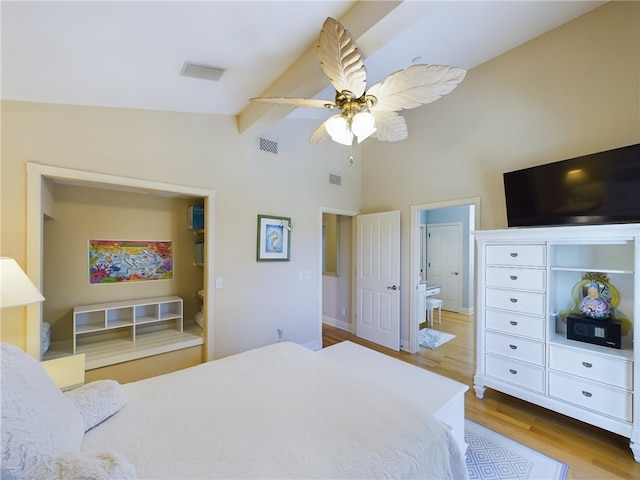 bedroom with ceiling fan, lofted ceiling with beams, ensuite bath, and light wood-type flooring