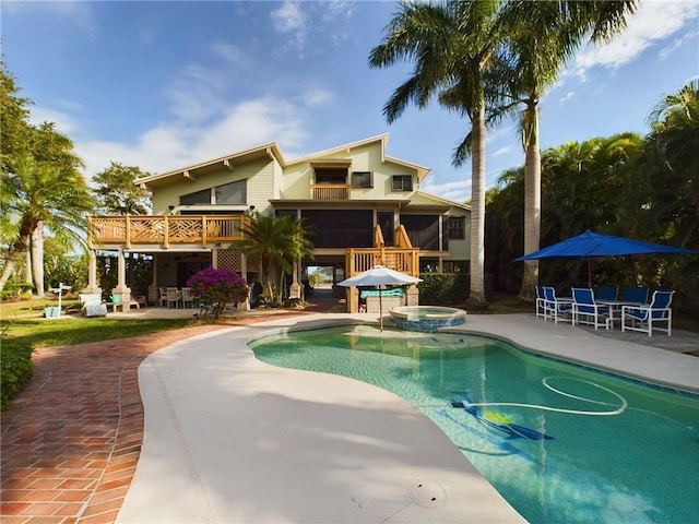 view of pool with an in ground hot tub, a sunroom, and a patio area