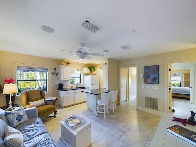 tiled living room with sink and ceiling fan