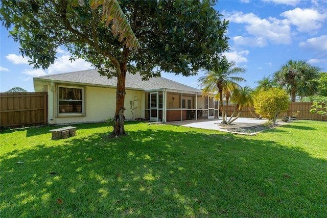 back of house featuring a sunroom, a patio area, and a lawn