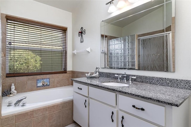 bathroom featuring vanity and independent shower and bath