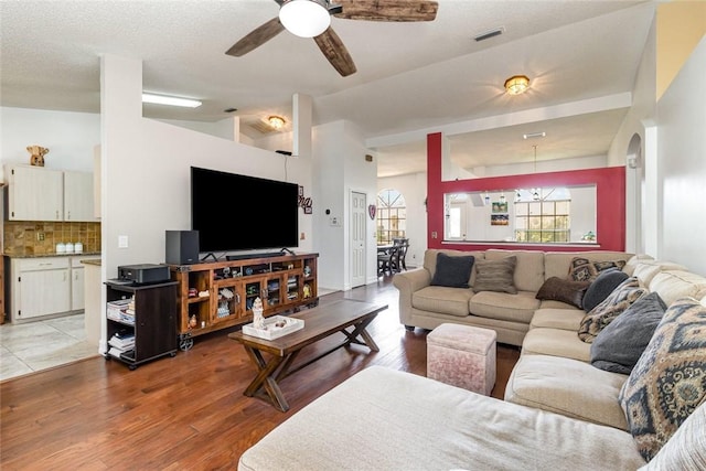 living room with vaulted ceiling, ceiling fan, and light hardwood / wood-style flooring