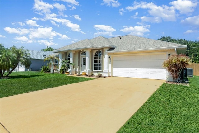 ranch-style home featuring a garage, central AC, and a front yard