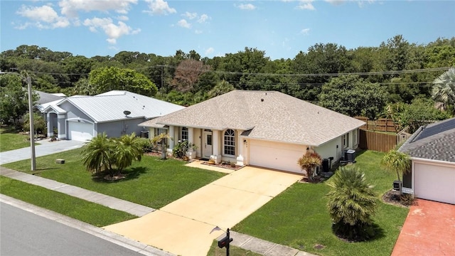 ranch-style home featuring a garage, a front lawn, and central air condition unit