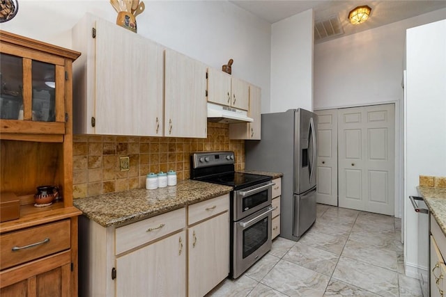 kitchen featuring appliances with stainless steel finishes, light stone countertops, decorative backsplash, and light brown cabinets