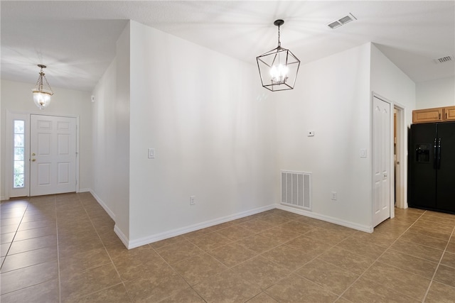 foyer entrance with tile patterned floors and a notable chandelier