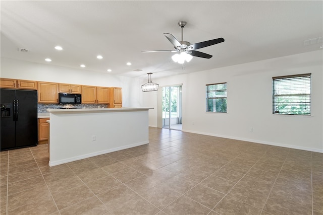 kitchen featuring light tile patterned floors, a wealth of natural light, and black appliances