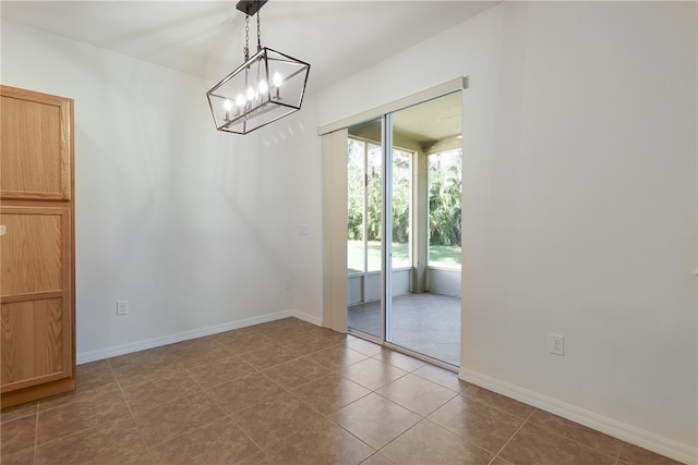 unfurnished dining area with dark tile patterned flooring and an inviting chandelier