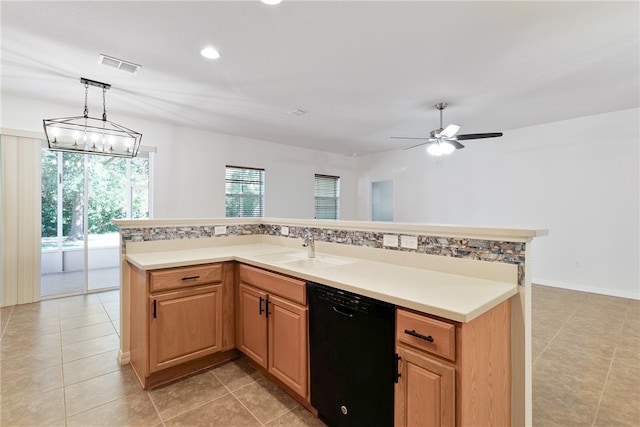 kitchen featuring ceiling fan with notable chandelier, sink, dishwasher, hanging light fixtures, and an island with sink