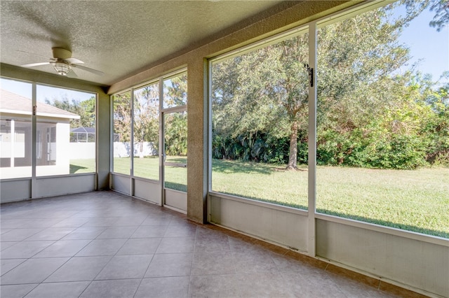 unfurnished sunroom featuring ceiling fan and a wealth of natural light