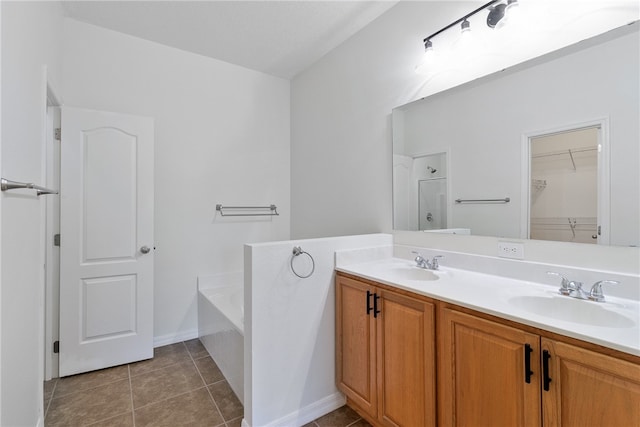 bathroom with tile patterned flooring, a bathtub, and vanity