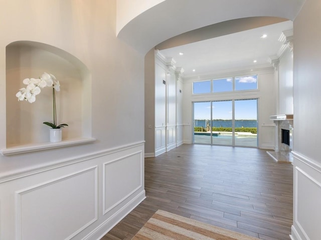 235 Osprey Ct, Vero Beach, FL 32963 - corridor with a decorative wall, wood finished floors, arched walkways, crown molding, and wainscoting