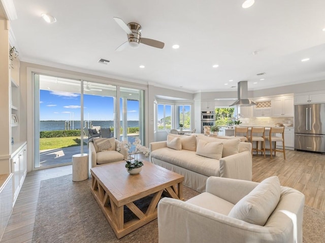 235 Osprey Ct, Vero Beach, FL 32963 - living room featuring crown molding, light wood-style floors, a ceiling fan, recessed lighting, and a water view