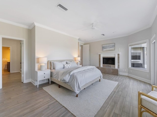 235 Osprey Ct, Vero Beach, FL 32963 - bedroom with light wood-style floors, ornamental molding, a ceiling fan, and a fireplace with raised hearth