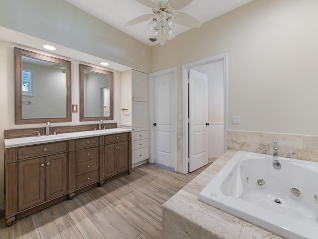 235 Osprey Ct, Vero Beach, FL 32963 - full bathroom with double vanity, wood finished floors, a whirlpool tub, and ceiling fan