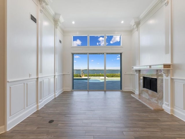 235 Osprey Ct, Vero Beach, FL 32963 - unfurnished living room with a decorative wall, ornamental molding, a fireplace, dark wood finished floors, and recessed lighting
