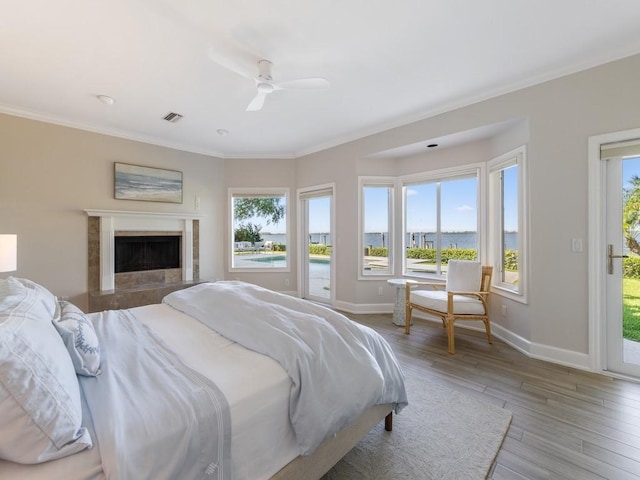 235 Osprey Ct, Vero Beach, FL 32963 - bedroom with access to exterior, wood finished floors, multiple windows, crown molding, and a water view