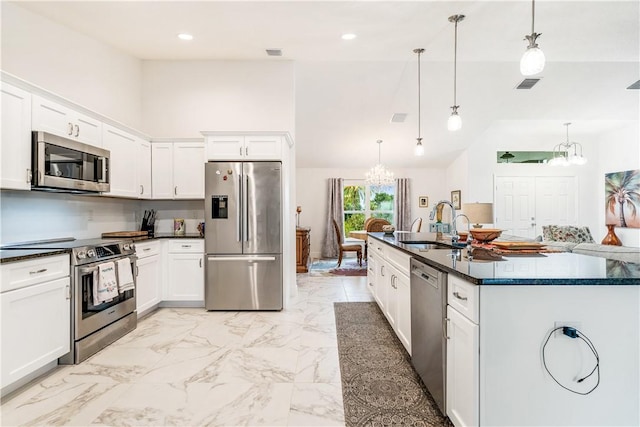 760 Holden Ave, Sebastian, FL 32958 - kitchen with stainless steel appliances, a chandelier, dark countertops, vaulted ceiling, and white cabinetry