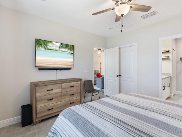 tiled bedroom featuring ceiling fan and ensuite bath