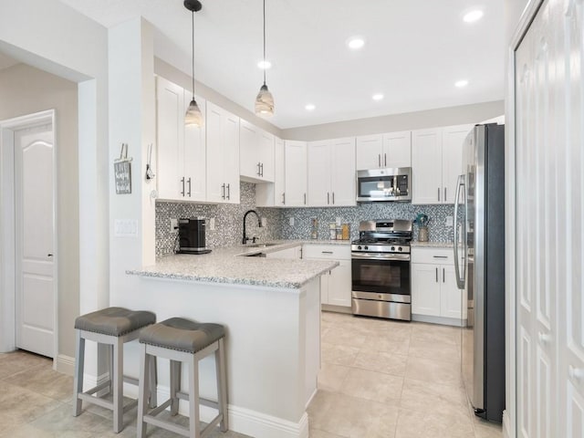 kitchen with white cabinets, appliances with stainless steel finishes, and kitchen peninsula