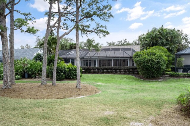 exterior space with glass enclosure and a front yard