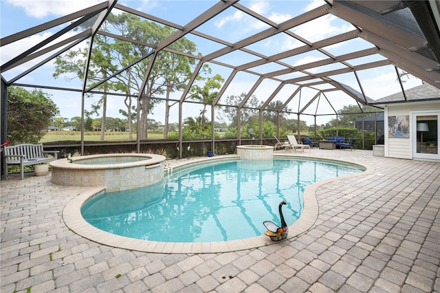 view of swimming pool featuring a lanai, a pool with connected hot tub, and a patio