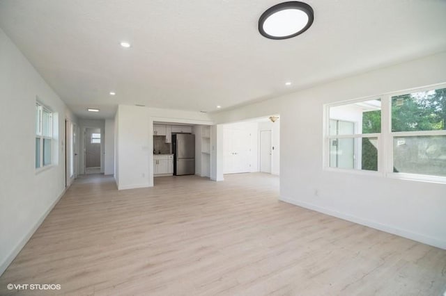 7645 58th Ave, Vero Beach, FL 32967 - unfurnished living room featuring light wood-type flooring, recessed lighting, and baseboards