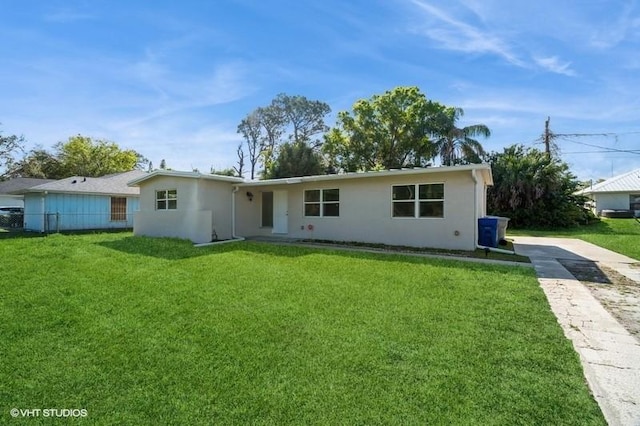 7645 58th Ave, Vero Beach, FL 32967 - rear view of house featuring concrete driveway, a yard, stucco siding, and fence