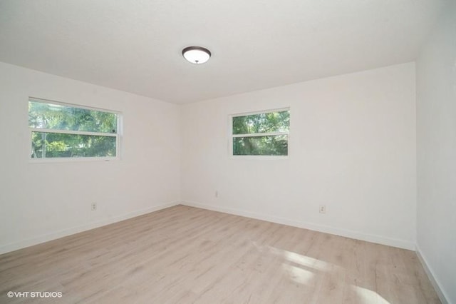 7645 58th Ave, Vero Beach, FL 32967 - unfurnished room featuring baseboards, light wood-type flooring, and a wealth of natural light